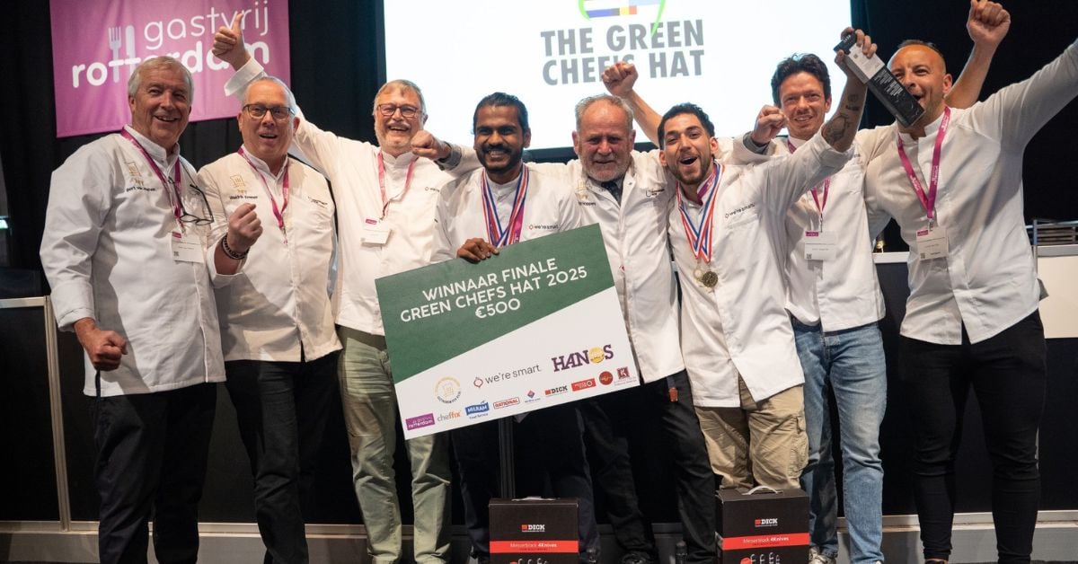 Acht mannelijke chefs die lachend naast elkaar staan op het podium met een cheque van 500 euro