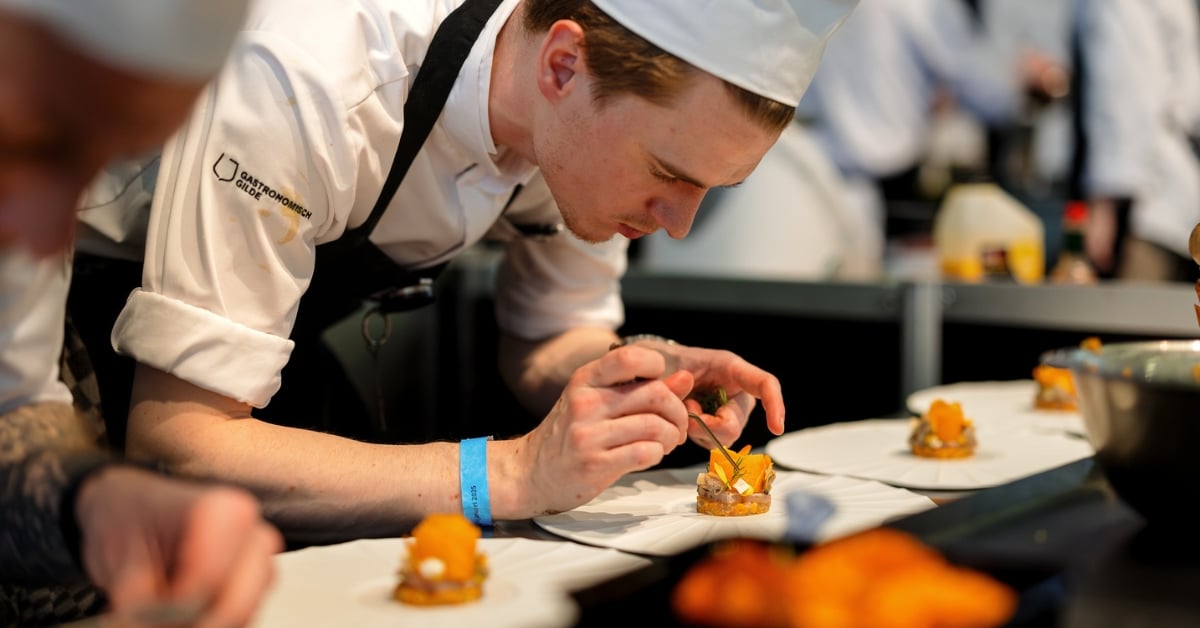 Chef-kok die een gerecht zorgvuldig afmaakt in een professionele keuken
