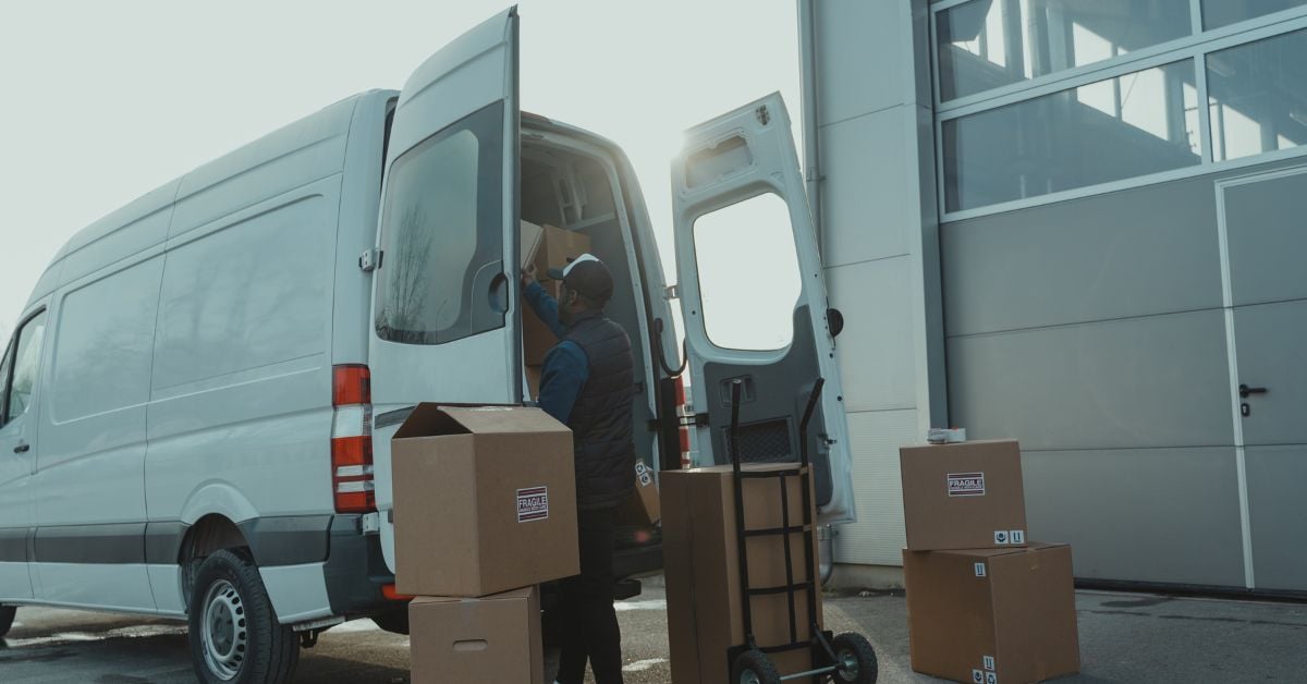 Bezorger die pakketten uit een bestelwagen haalt