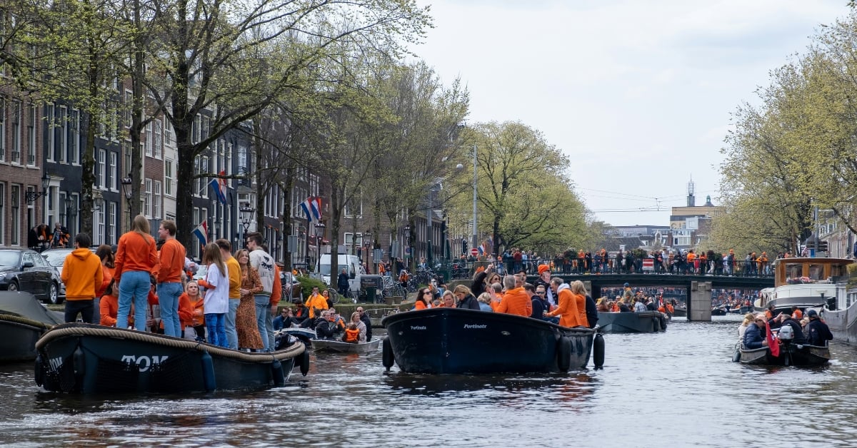 Boten in de grachten van Amsterdam met Koningsdag
