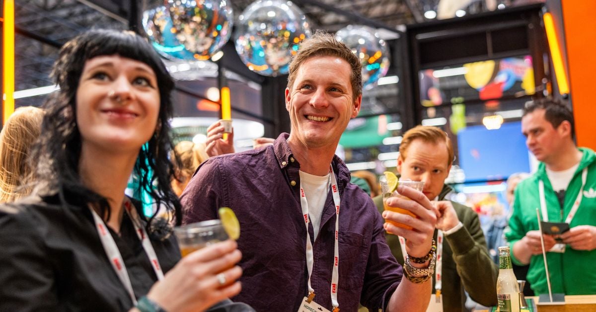 Vier mensen drinken lachen en drinken een drankje
