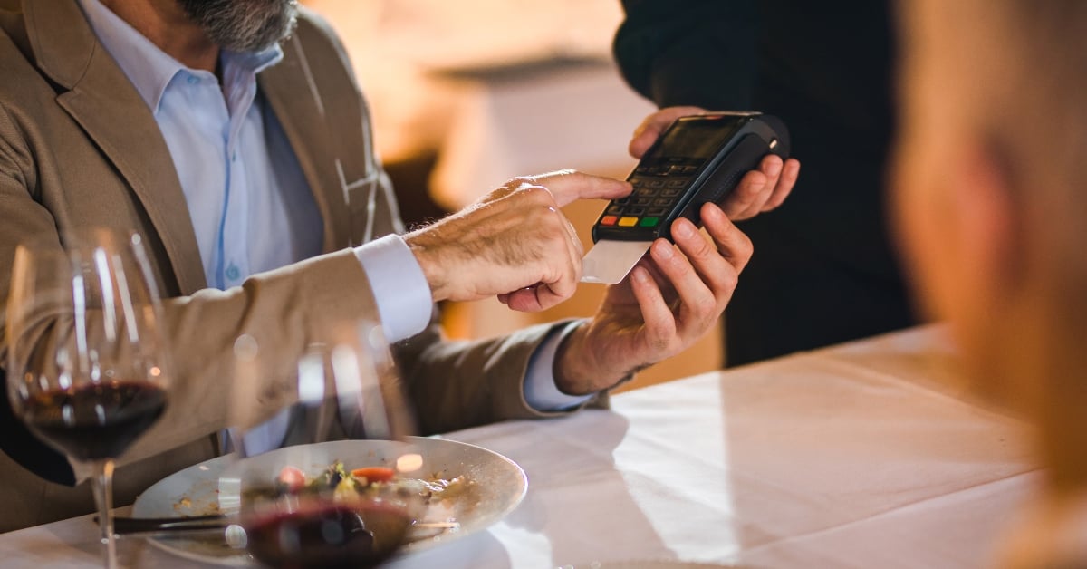 Man rekent af met een pinpas op een pinautomaat in een restaurant.