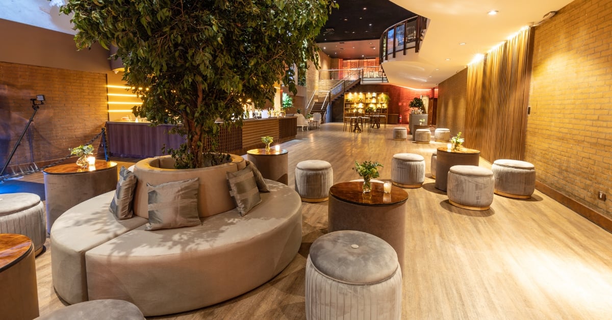Stijlvolle hotel lobby met grote boom, ronde zithoek en moderne verlichting