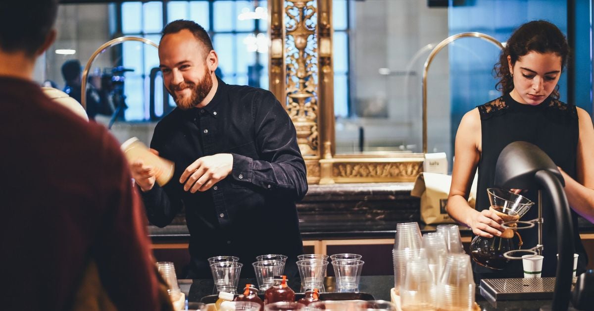 Medewerkers achter de bar verzorgen drankjes voor gasten