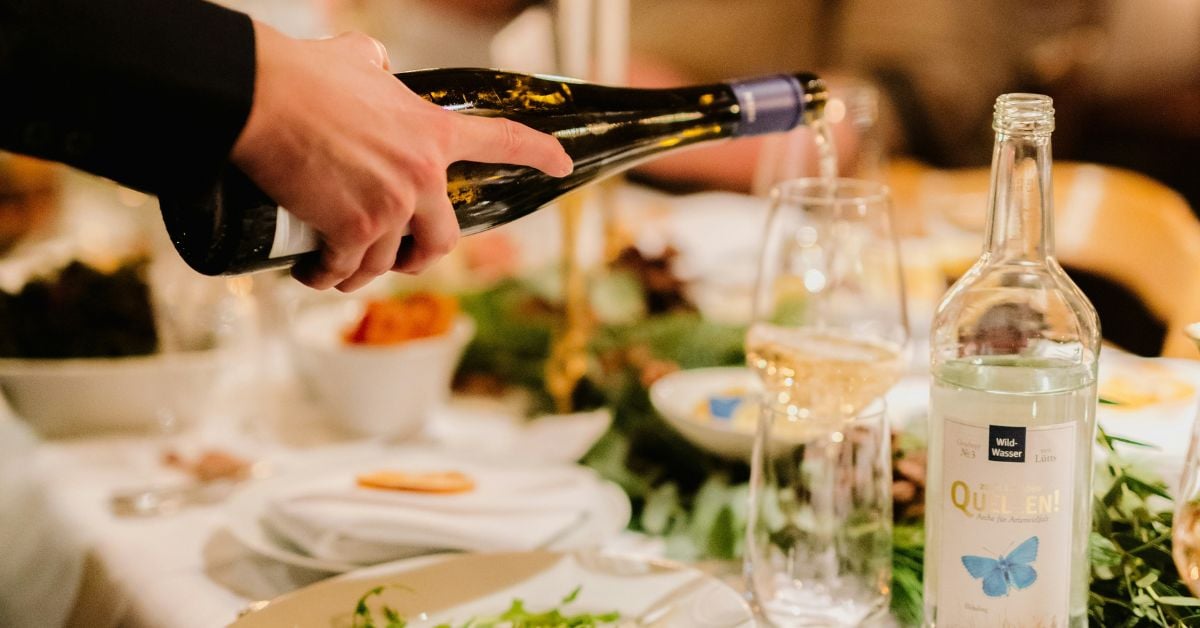 Medewerker schenkt wijn in aan tafel in een restaurant
