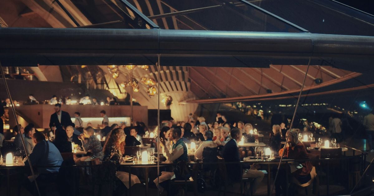 Drukbezocht restaurant met gasten aan tafels bij warme sfeerverlichting