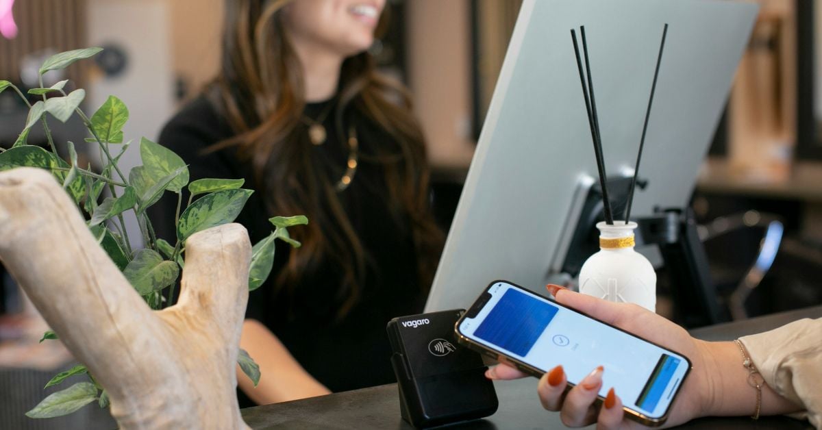 Gast gebruikt smartphone bij de receptie van een hotel