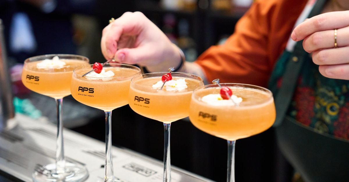 Vier cocktails op een bar met garnering