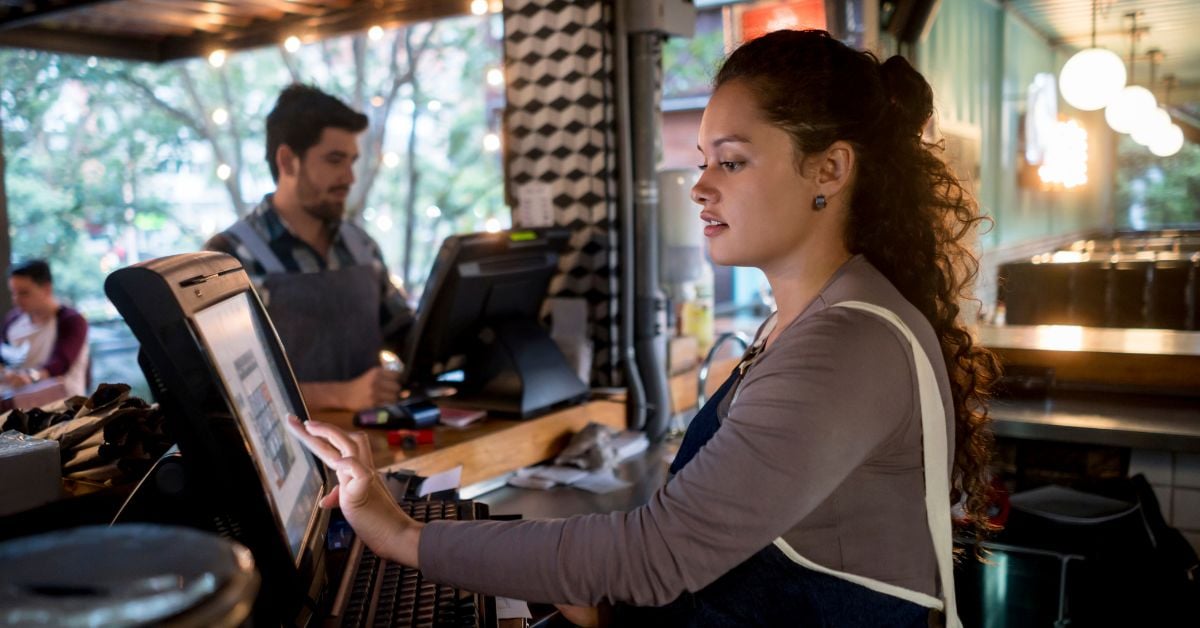 Medewerker gebruikt kassasysteem in restaurant
