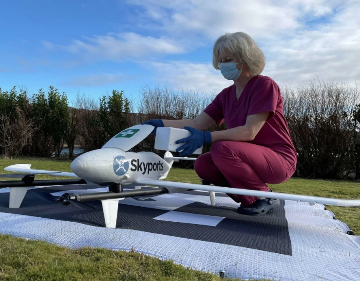 Nurse placing a medical package into a Skyports drone during a CAELUS trial in Scotland