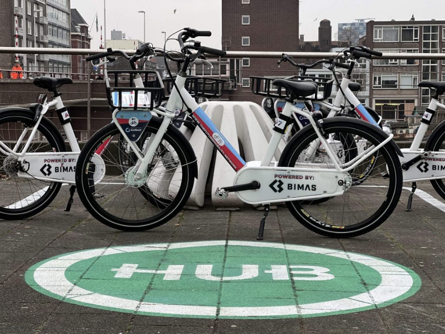 Shared bikes parked on a clearly marked “HUB” zone in Amsterdam, showing a real-life mobility hub pilot.
