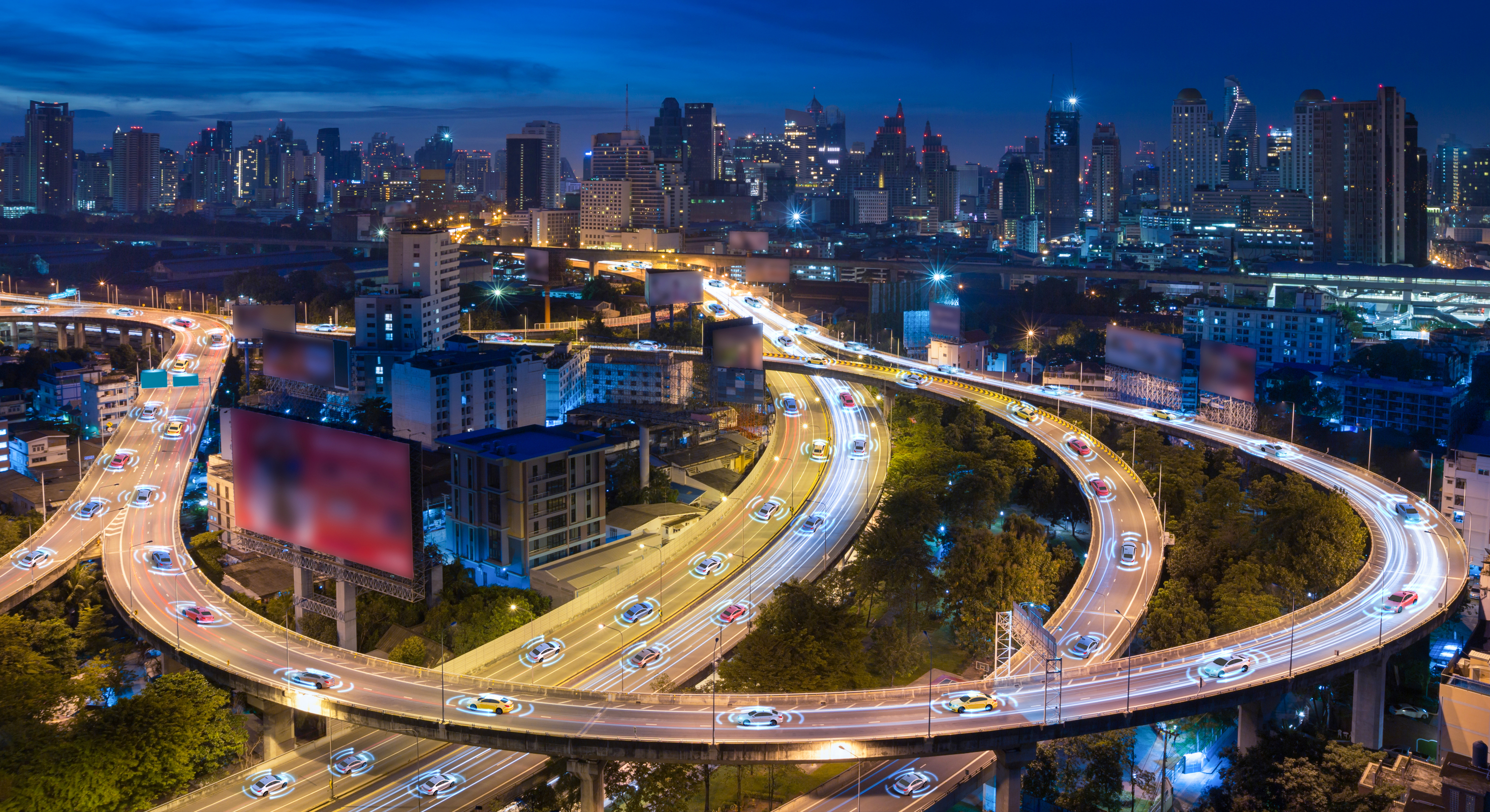 Nighttime aerial view of multilayer highways with connected autonomous vehicles visualized on lanes