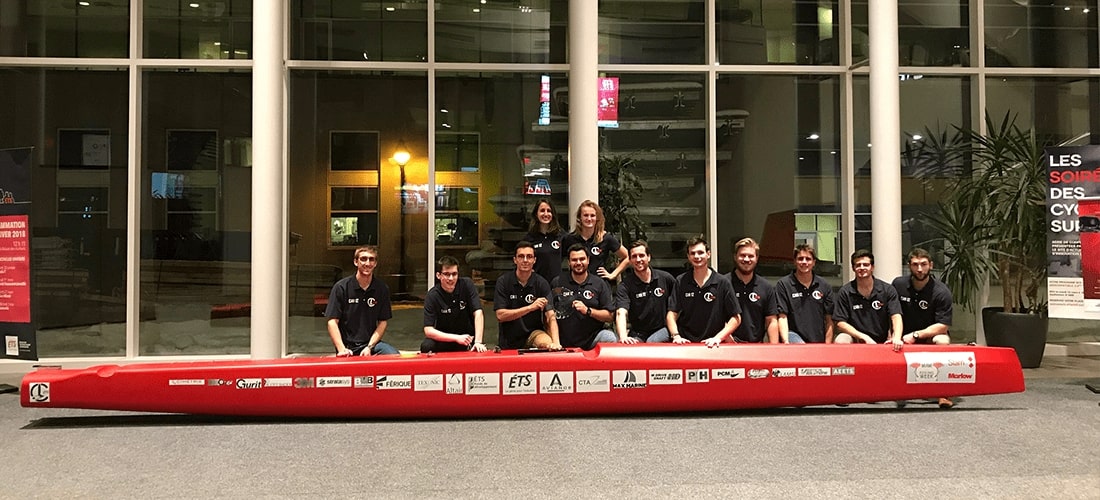 Team members of the ETS Rafale project posing with their high-performance C-Class catamaran, developed and built by engineering students for international hydrofoiling competition.