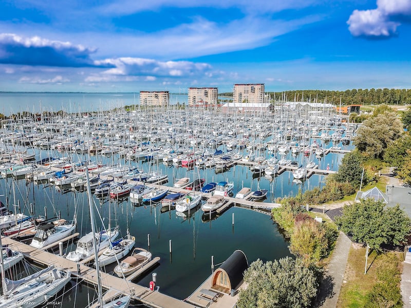Aerial view of Marina Muiderzand with numerous boats moored in the harbour and surrounding waters.