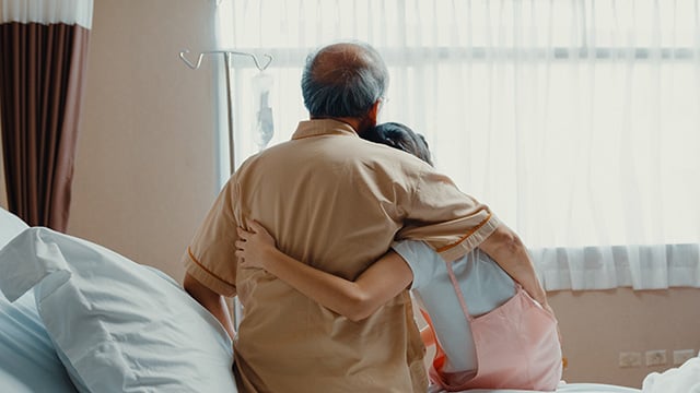 granddaughter visiting  grandfather hospitalized sit on hospital bed