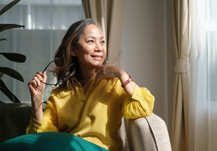 A woman sitting in a chair looking out of window