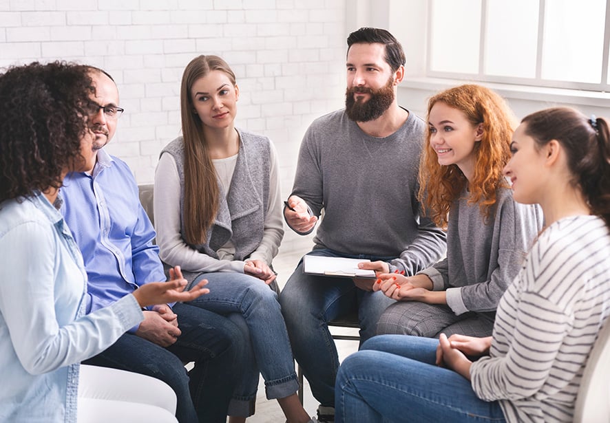 A group of people sitting together listening to one another