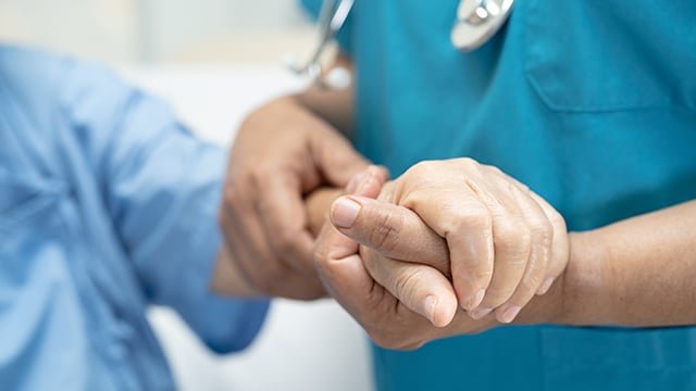 Doctor holding touching hands senior or elderly older woman patient