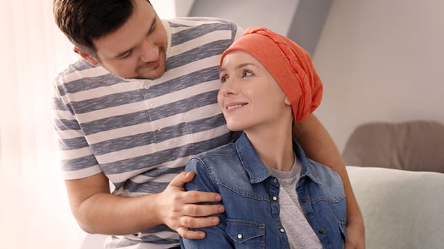A man embracing a woman wearing a head covering