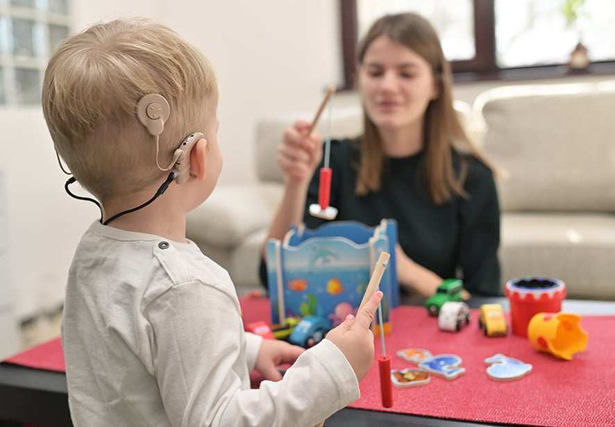 A young boy With Cochlear Implants Playing with his mom