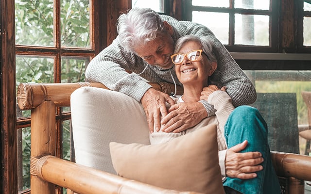 A couple smiling and embracing in the comfort of their home