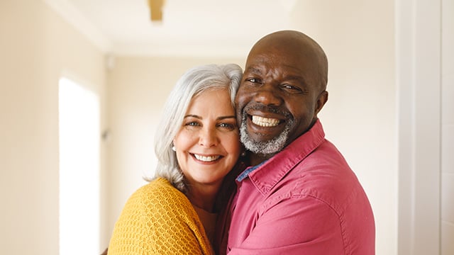 happy diverse senior couple embracing and smiling 