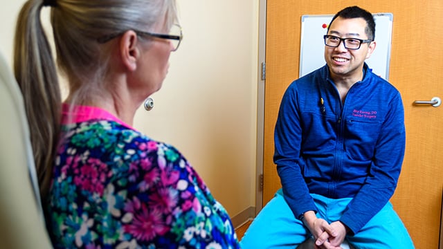 Reid Health Vascular Surgeon Dr.  Brian Kwong smiling at a patient