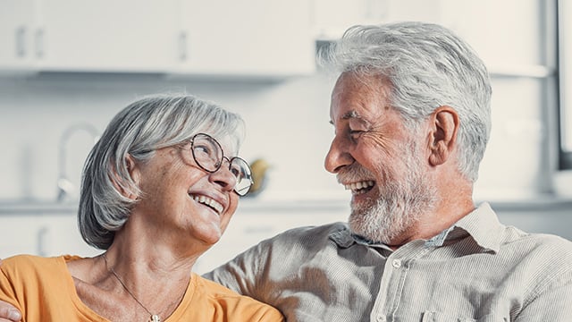 A older man and a women looking at each other smiling