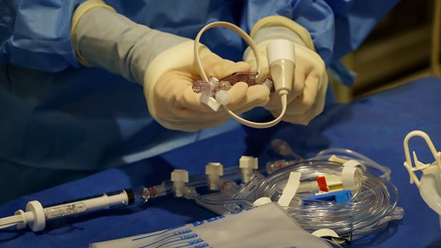 A member in the cardiac cath lab working to prepare for a procedure 