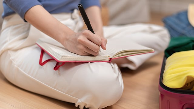A close-up image of a person creating a checklist for packing