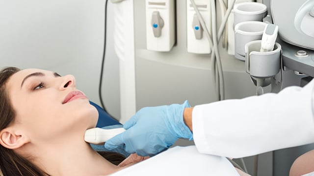 A woman having an ultrasound done on her neck