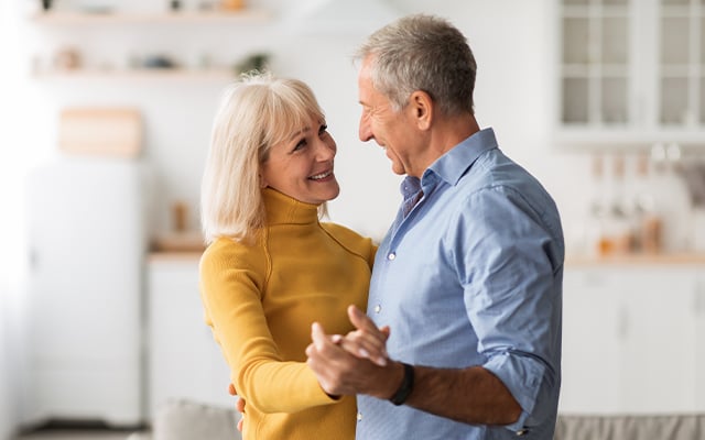 A senior couple dancing in their home