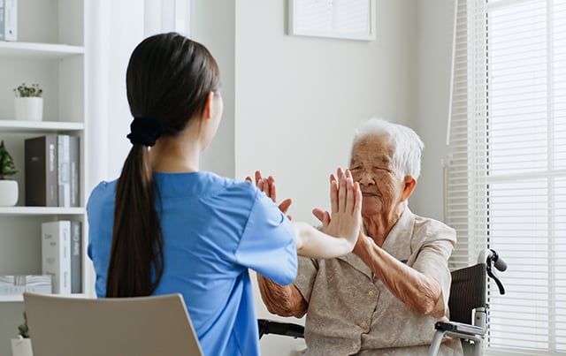 A home health nurses health a woman in a wheel chair do Physical Therapy 