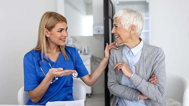 A nurse and an older women patient interacting with each other