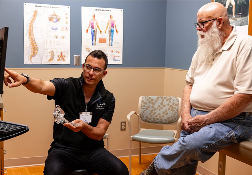 Ted Kostiuk, DO talking with a patient post surgery 