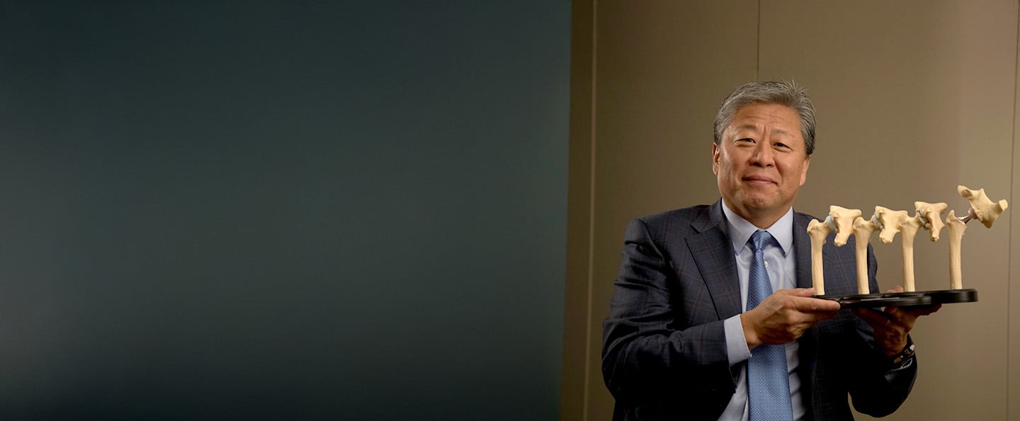 Reid Health's, Mario Lee, MD holding a display of hip models 