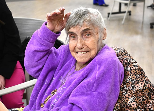 A PACE participant smiling with a purple sweater on 
