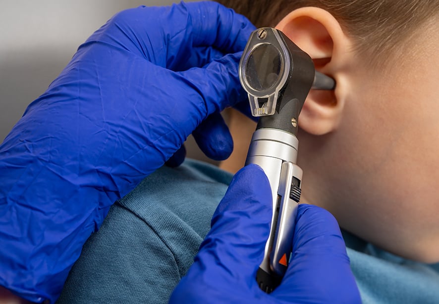 A close up image of a young boys having his ears examined 