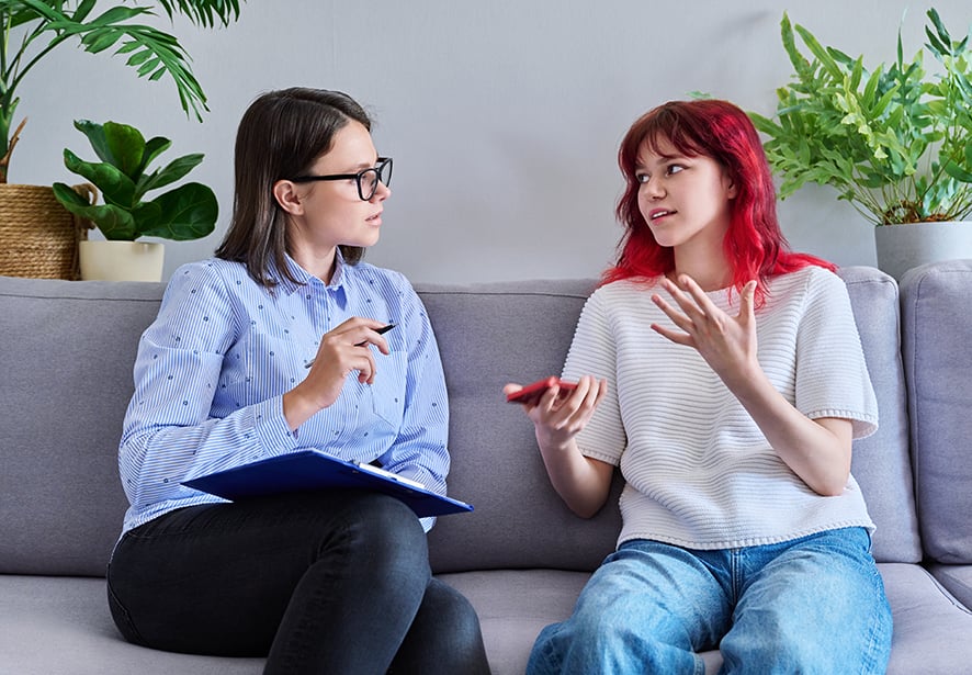 A teenage girl talking with a mental health professional