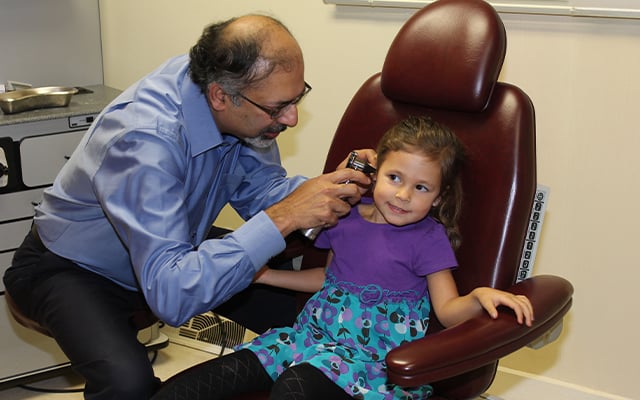 Reid health's Rohit Bawa, MD examining a child