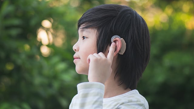 Asian child with hearing aid