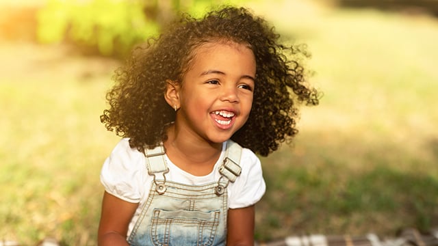 Happy african-american girl walking in park