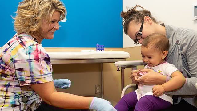 A medical assistant interacting with pediatric patient