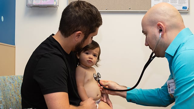Reid Health Dr. Martin Munoz, examining a child