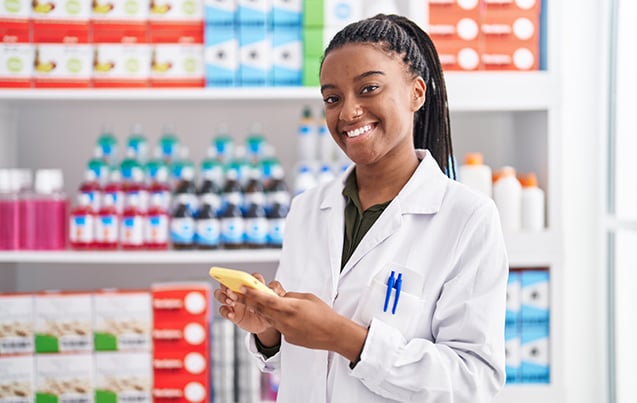 A pharmacy employee working and smiling 