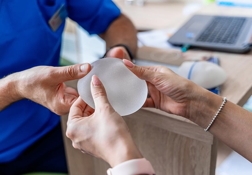 A doctor showing a patient breast implants 