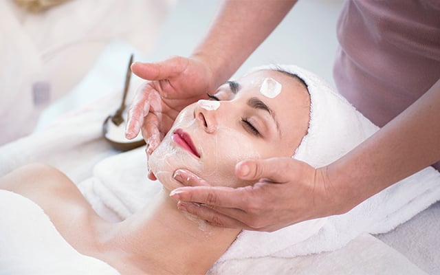 A woman in a spa receiving a facial
