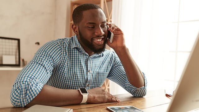 A young man on the phone scheduling an appointment