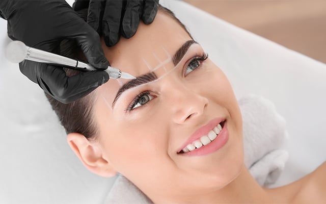 A women receiving an eyebrow permanent makeup procedure