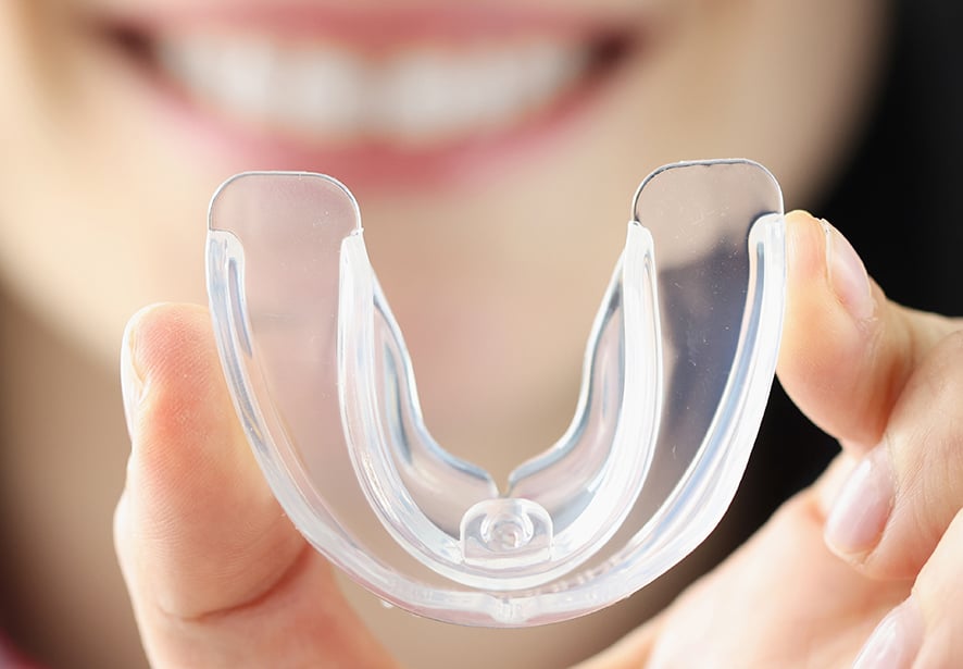 A woman holding a mouth guard